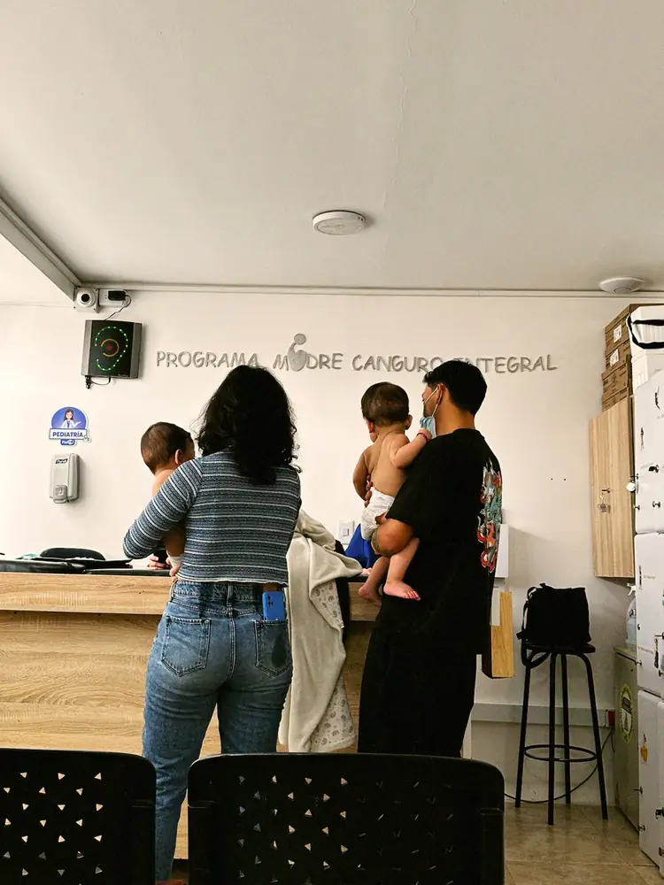 Familias con sus bebés en la sala del programa, vistas de espaldas